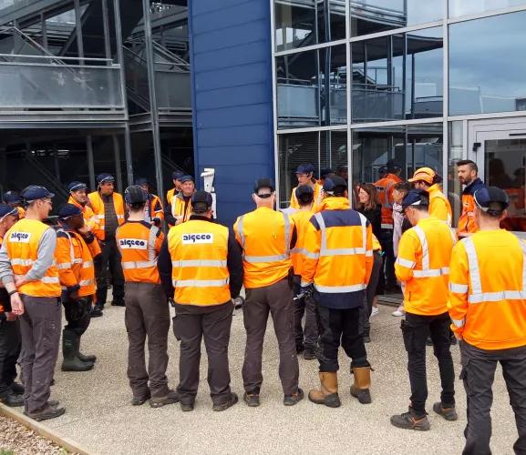 groupe d’intervenants d’Algeco en tenue de sécurité devant un bâtiment industriel ou commercial