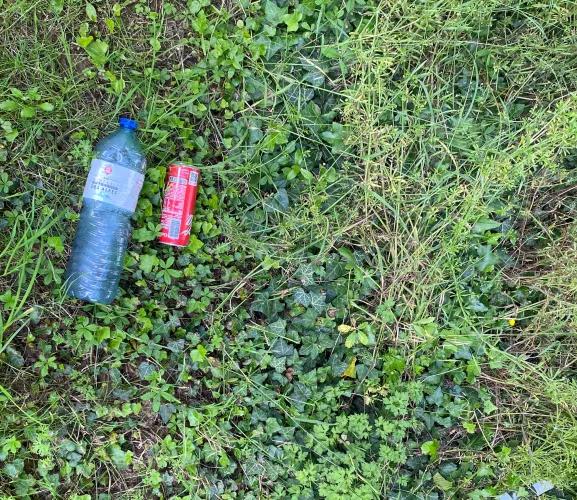 bouteille en plastique et canette abandonnées sur l'herbe