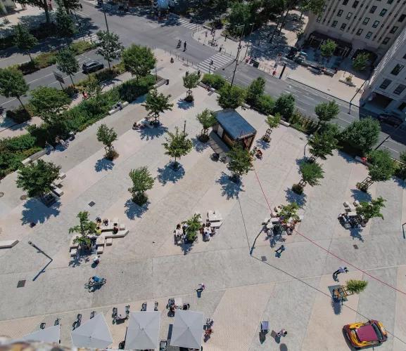 Vue aérienne d'une place urbaine avec arbres, piétons et kiosque modulaire ALGECO®