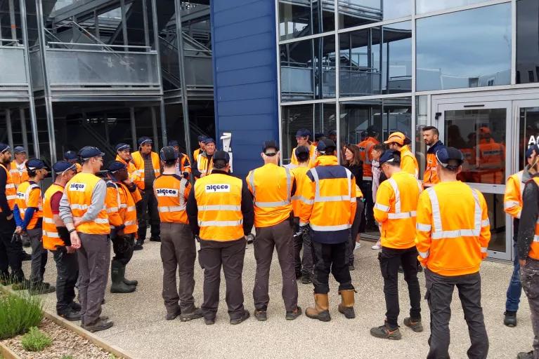 groupe d’intervenants d’Algeco en tenue de sécurité devant un bâtiment industriel ou commercial