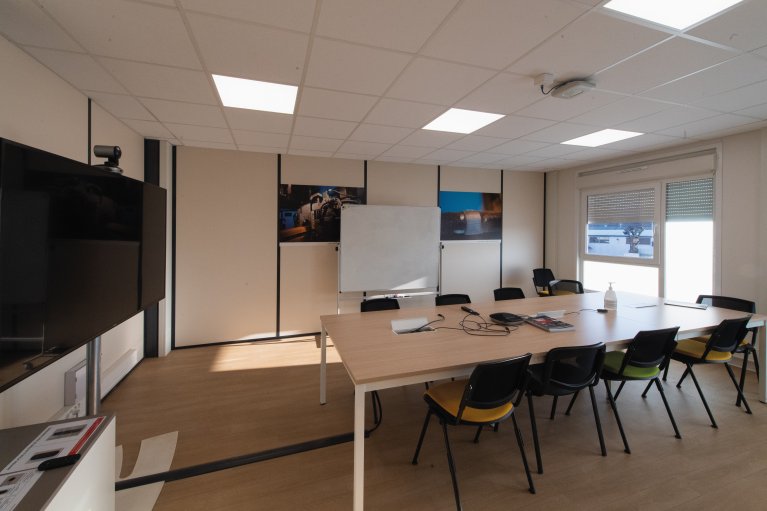 Salle de réunion modulaire moderne ALGECO® avec télévision pour vidéoconférence et tableau blanc