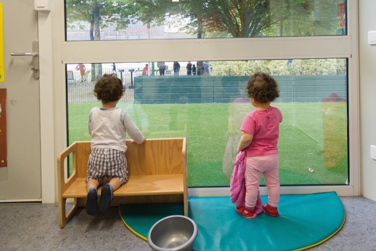 Enfants regardant vers l’extérieur d’une crèche modulaire ALGECO®