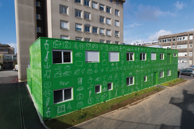 Bâtiment modulaire ALGECO® annexe d'hôpital avec façade verte ornée de dessins ludiques