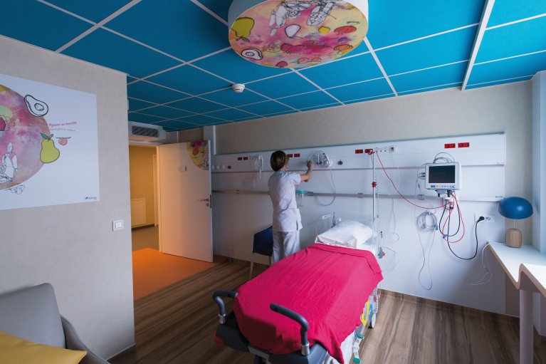 Chambre d'hôpital modulaire ALGECO® moderne avec lit médical et personnel ajustant l'équipement