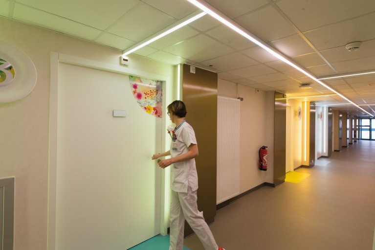 Personnel médical ouvrant la porte d'une chambre dans un couloir d'hôpital modulaire moderne ALGECO®