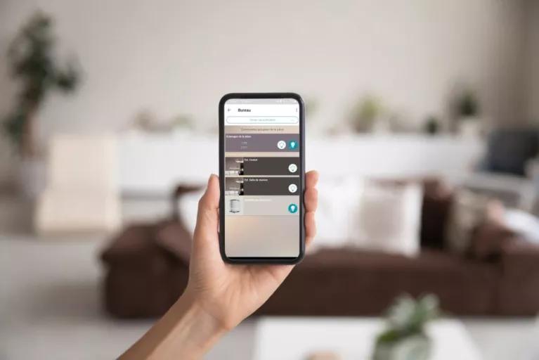 Application domotique Algeco GTB affichée sur un smartphone dans un intérieur moderne