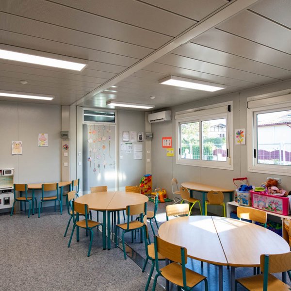 Salle de classe modulaire ALGECO® avec deux tables rondes pour enfants