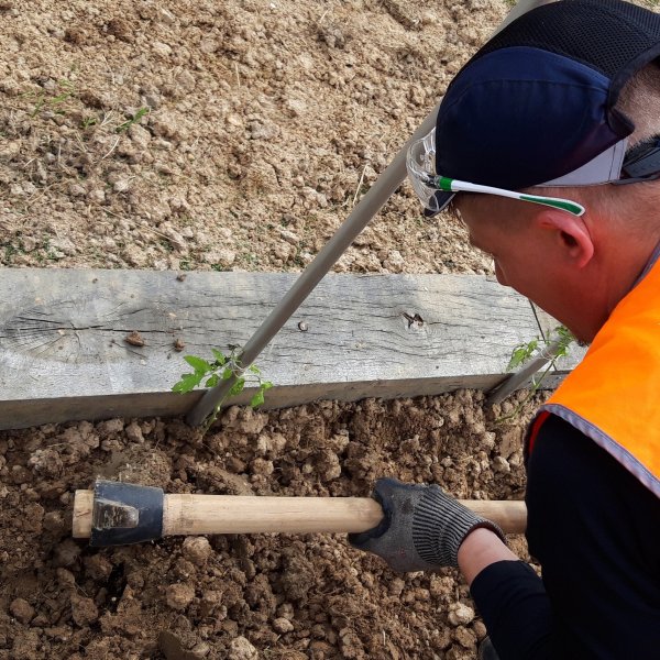 expert Algeco creusant la terre avec une pioche