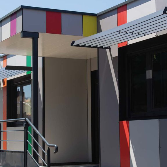 vue extérieure des salles de classe modulaires ALGECO® avec façade colorée, auvent, et rampe d’accès pour l’école primaire de Chanteranne à Clermont Ferrand